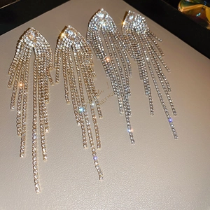 Detail of long tassel earrings with sparkling crystals in gold and silver finishes