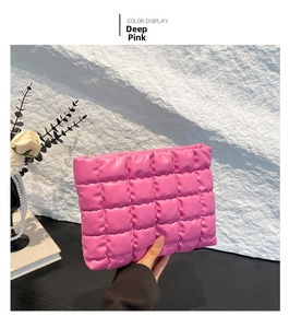 Détail d'une trousse à maquillage matelassée rose foncé avec fermeture éclair métallique