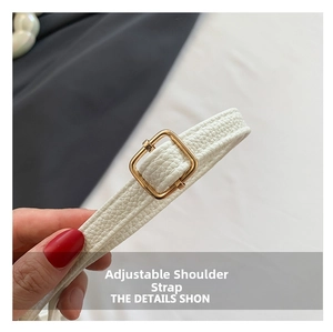 Close-up of adjustable white PU leather strap with gold buckle on a crossbody bag
