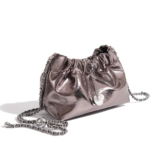 Detail of metallic silver pleated cloud bag with elegant pearl and metal ball charms