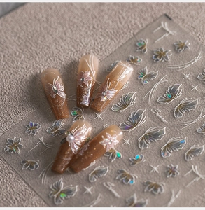 Macro detail of holographic butterfly nail stickers with floral patterns on brown gradient nails