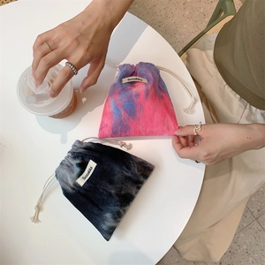 Casual tie-dye corduroy drawstring pouch bags with Sozakka brand label on a white table