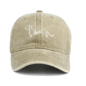 Close-up of white dachshund and love embroidery on khaki washed cotton baseball cap