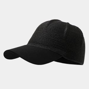Detailed side view of the woven straw texture and black fabric brim on the baseball cap