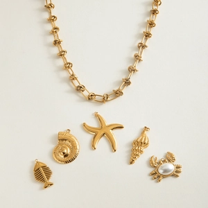 Detail van 18K goud roestvrijstalen ketting met zeedierbedeltjes op witte ondergrond