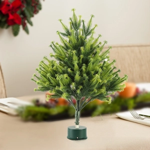 Close-up of a mini flocked artificial Christmas tree with a round green base and layered needles