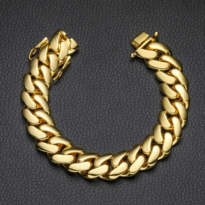 Close-up of golden Cuban link bracelet with butterfly clasp on black leather background