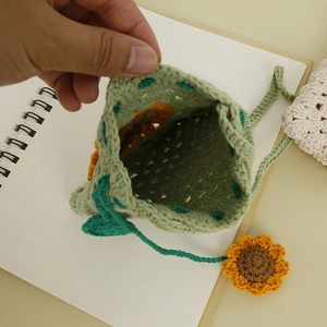 Handmade green knitted crossbody bag with 3D sunflower and drawstring closure