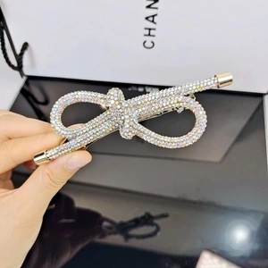 Dettaglio del fermaglio per capelli a fiocco dorato con strass su sfondo di lusso