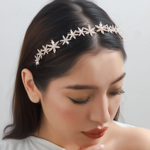 Détail de serre-tête en or rose avec étoiles, cristaux et perles brillantes
