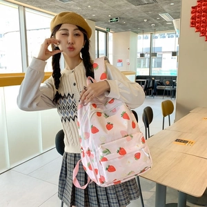 Detailed view of pink school backpack with cute strawberry prints and flower patterns