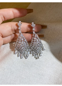 Detailed close-up of luxury silver-toned drop earrings featuring sparkling zircon tassels