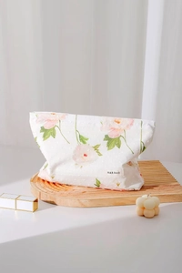 Dettaglio ravvicinato della borsa per trucco in cotone floreale con etichetta