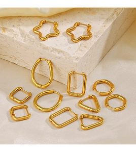 Golden geometric earring set with stars and hexagons on silk and stone background