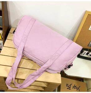 Detailed view of a stylish large capacity pink travel duffel bag placed on a wooden pallet.
