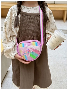 Détail du sac coeur rose avec étoile pailletée et bandoulière arc-en-ciel sur enfant