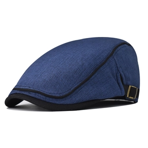 Detail of navy cotton flat cap showing woven texture and bronze adjustable metal buckle