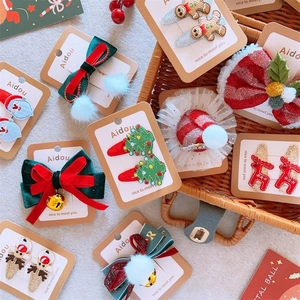 Detailed view of Christmas hair clips with reindeer, gingerbread man, and mesh bow designs