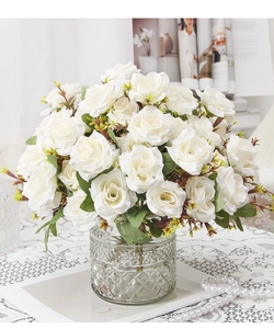 Elegant artificial white roses in a textured glass vase for sophisticated home decoration