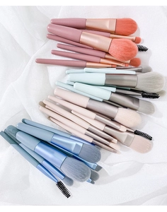 Flat lay of four portable mini makeup brush sets in pink, mint, beige, and blue themes