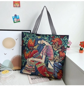 Close-up of vibrant floral jacquard tote bag with stylish black and white striped straps