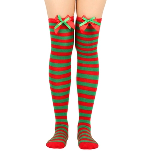 Detail of red and green striped over-knee socks with festive satin bows on white background