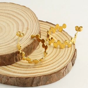 Fashionable 18k gold irregular round earrings displayed on natural wooden slices