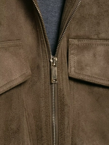 Detail of coffee brown suede jacket showing metallic zipper and symmetrical pockets
