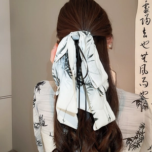 Detail of a large white ribbon hair clip with black ink wash bamboo print in oriental style