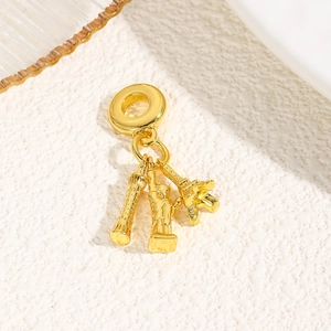 Detailed close-up of golden Eiffel Tower and Statue of Liberty charms for bracelets