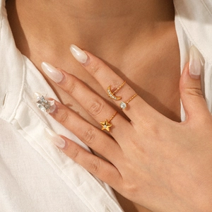 Detail of model wearing gold star and moon rings with sparkling zircon inlay
