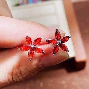 Detailed macro of red flower earrings with marquise-cut crystals and a silver finish