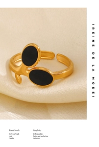 Macro shot of 18K gold plated adjustable leaf ring with black enamel details on silk