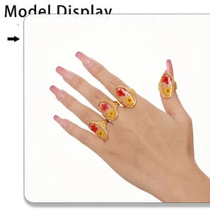 Detail of four gold rings featuring resin-encapsulated red and yellow dried flowers