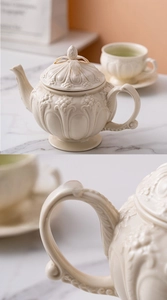 Detail of embossed floral patterns on cream ceramic teapot with underglaze finish