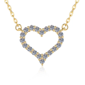 Détail d'un pendentif en forme de cœur avec cristaux blancs et chaîne dorée