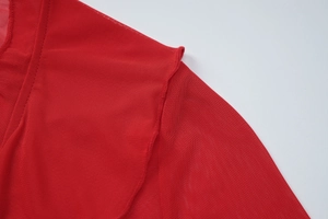 Détails du tissu en maille rouge montrant les coutures d'épaule et les volants délicats