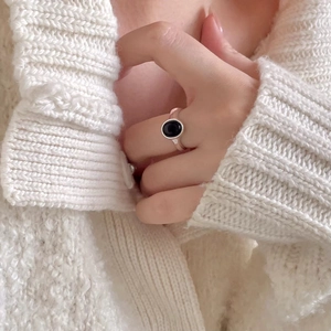 Close-up of minimalist S925 silver ring with oval black onyx gemstone on model's finger