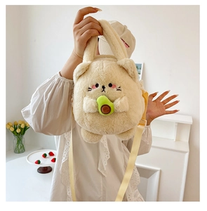 Cute cream cat plush crossbody bag with avocado toy detail, shown on model lifestyle view