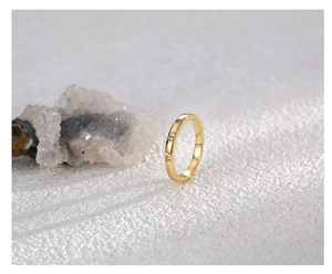 Close-up of a gold minimalist ring with three zircon stones on a white crystal stone