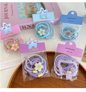 Detail of candy color flower hair tie set with scrunchies and bear charms on display