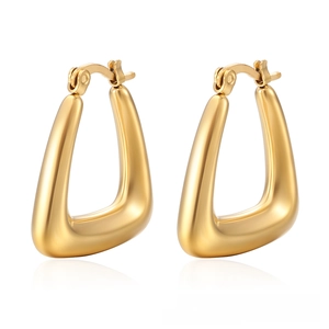 Macro detail of thick triangular gold earrings with polished 18K finish and clip-on closure