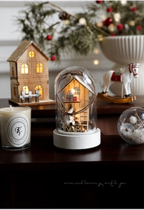 Detail of wooden Christmas glass dome ornament with warm LED lights and NOEL lettering