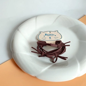 Detailed view of durable brown high-elastic hair ties on cute cat-shaped card packaging
