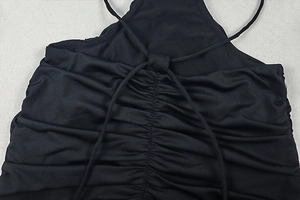 Detail of back criss-cross straps and ruched fabric on a sexy black backless maxi dress