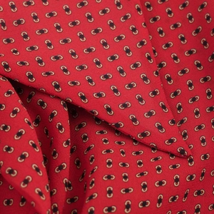 Gros plan sur un tissu de chemise rouge avec motifs chaînes et détails de tissage sergé