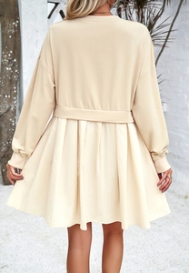 Vue détaillée du dos d'une mini-robe beige à manches longues avec jupe plissée et ceinture