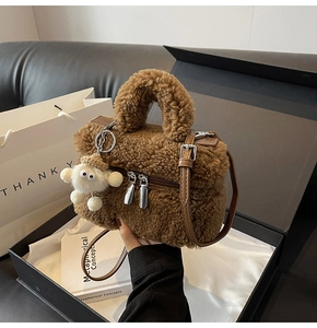 Close-up of brown faux fur handbag with lamb charm and leather strap in luxury gift box