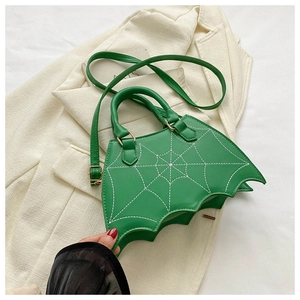 Dettaglio della borsa verde a forma di pipistrello con cuciture a ragnatela e anelli d'oro
