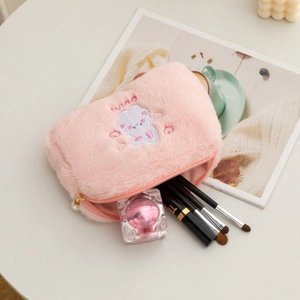 Detailed view of pink plush makeup bag with rabbit embroidery and spacious interior